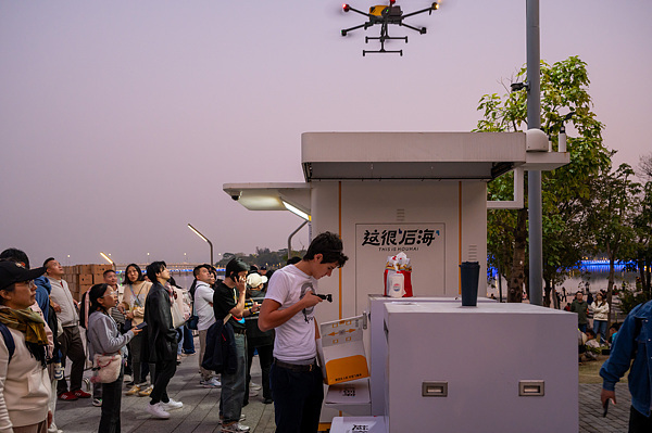 在深圳,外國(guó)游客體驗(yàn)無(wú)人機(jī)外賣(mài)送餐。