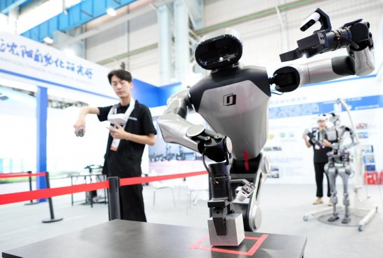 9月5日，在沈陽的2025全球工業(yè)互聯(lián)網(wǎng)大會(huì)的展覽區(qū)現(xiàn)場(chǎng)，中國(guó)科學(xué)院沈陽自動(dòng)化研究所的機(jī)器人工程師在調(diào)試具身智能操作系統(tǒng)。新華社記者 李鋼 攝